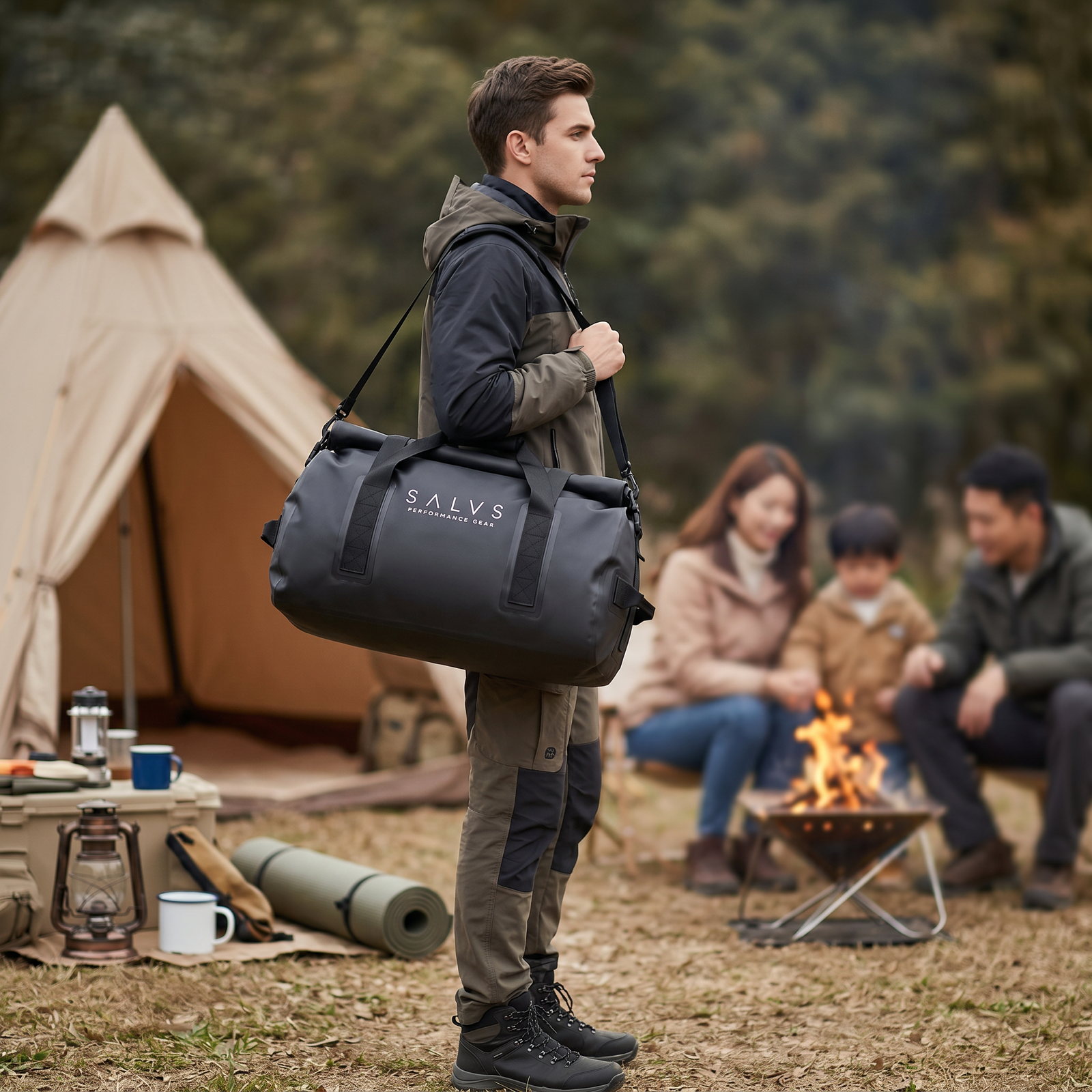 Man carrying a black SALVS duffel at a campsite.