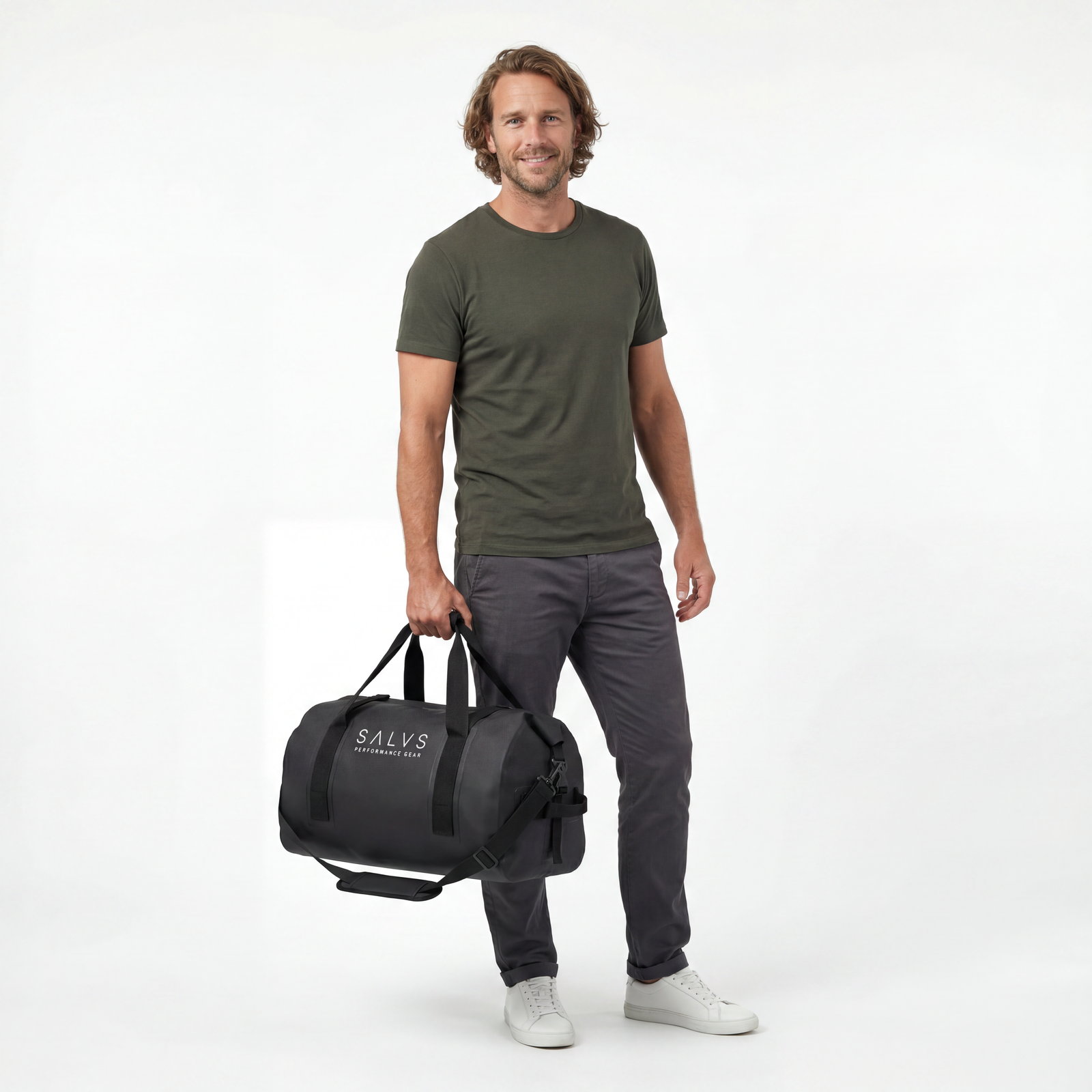 Man in an olive tee holding a black SALVS 60L duffel.